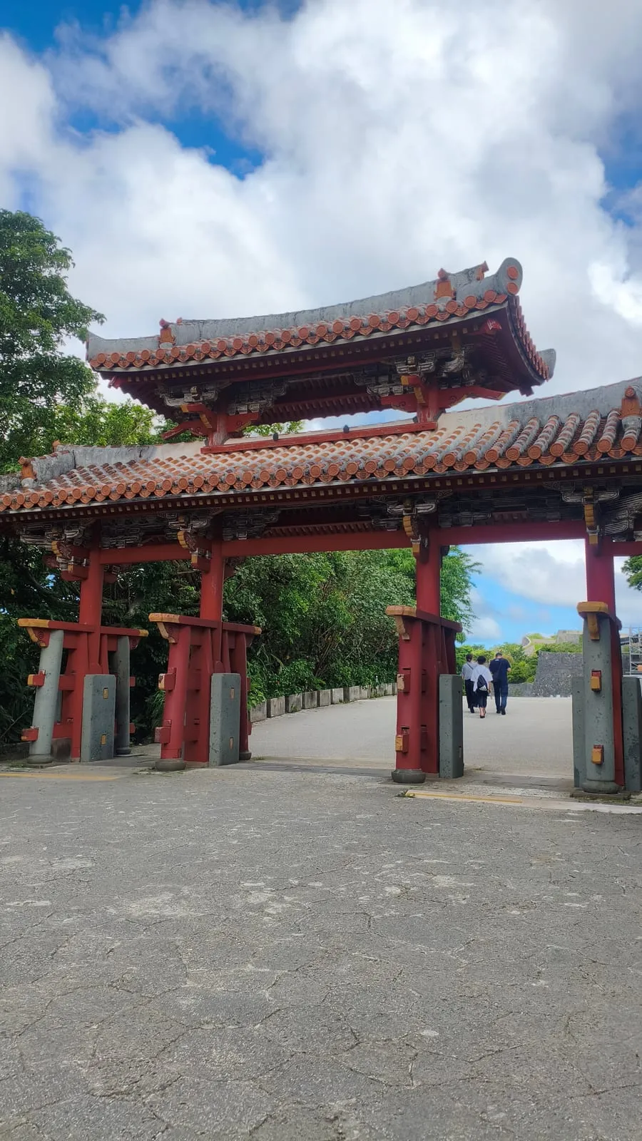 首里城公園の守礼門。赤い柱と赤瓦の門越しに園内の道が伸びている